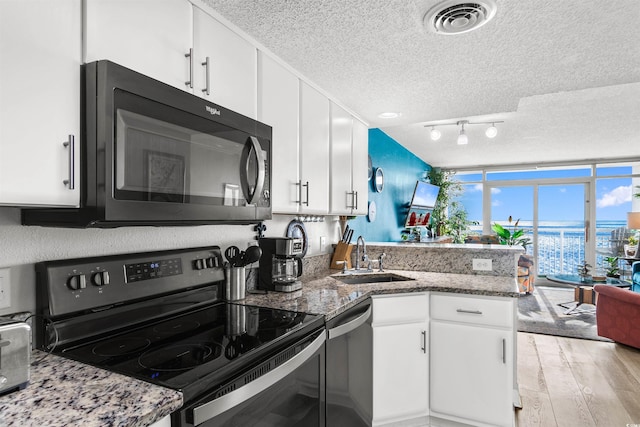 kitchen with white cabinetry, sink, kitchen peninsula, and black range with electric cooktop