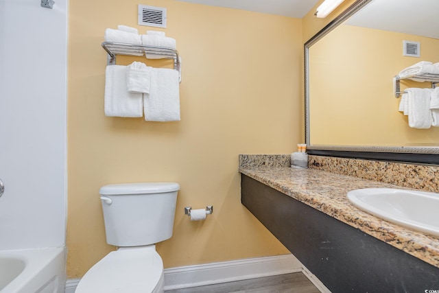 bathroom featuring vanity, toilet, and a bathing tub