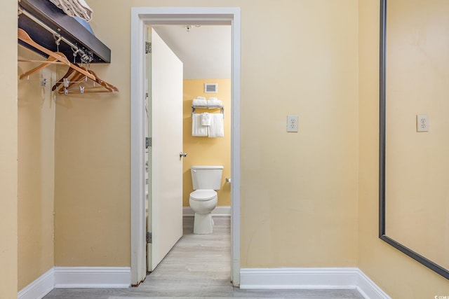 bathroom featuring hardwood / wood-style flooring and toilet