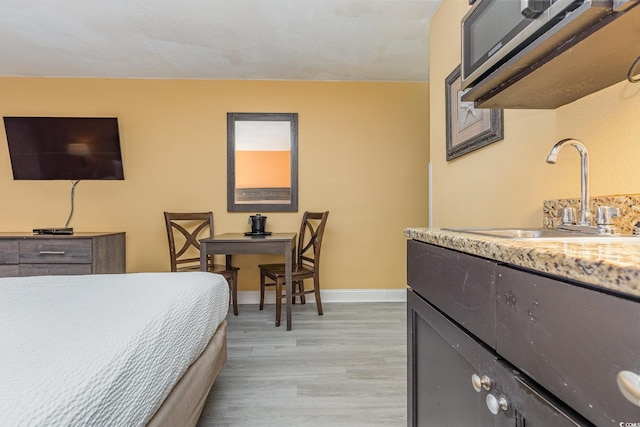 bedroom with light wood-type flooring and sink