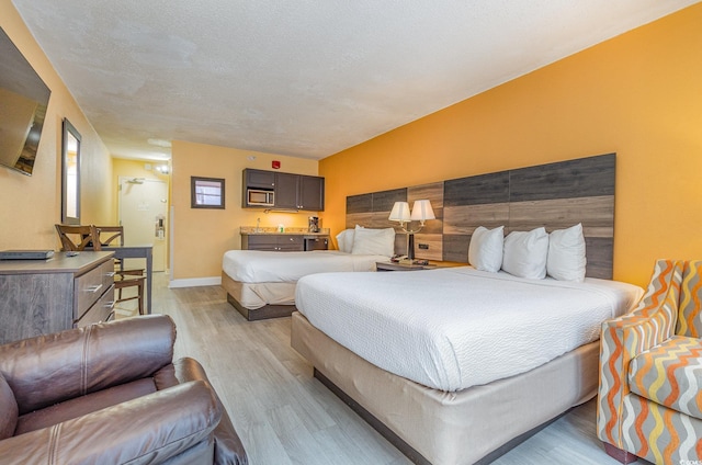 bedroom with a textured ceiling and light hardwood / wood-style floors