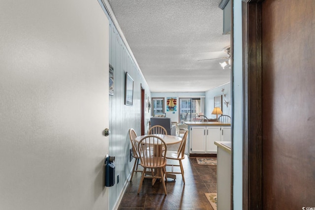 tiled dining space featuring a textured ceiling and ceiling fan