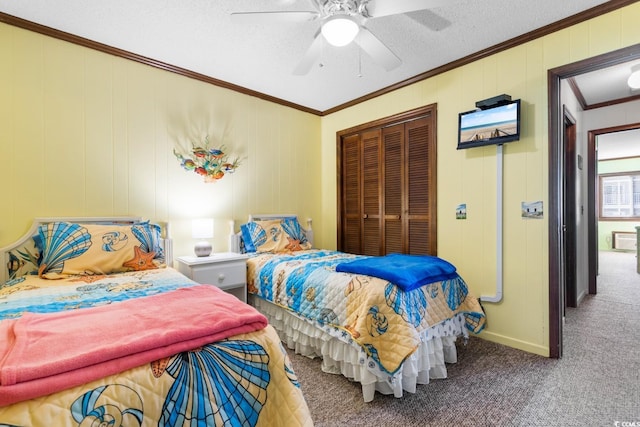 carpeted bedroom featuring ceiling fan, ornamental molding, a textured ceiling, and a closet