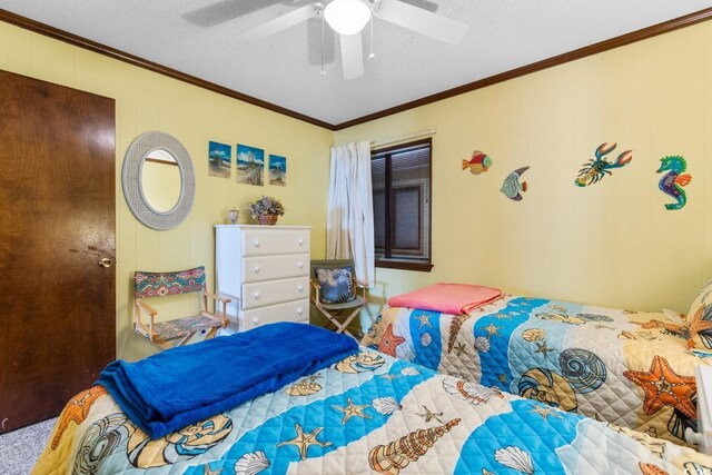 bedroom featuring ceiling fan, crown molding, carpet floors, and wooden walls