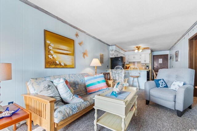 carpeted living room featuring crown molding and ceiling fan