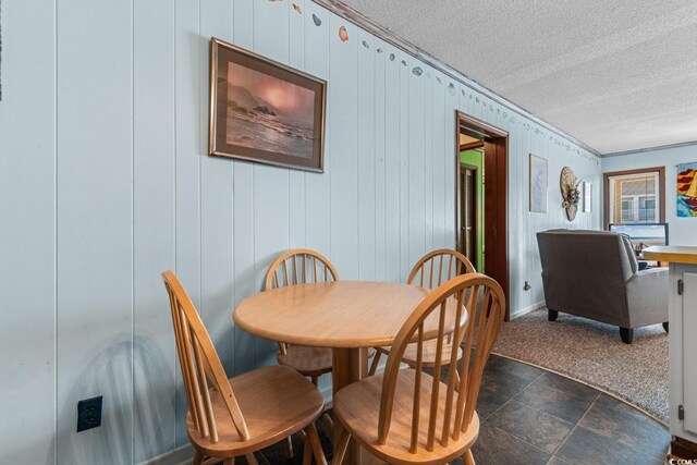 dining area with wood walls and a textured ceiling