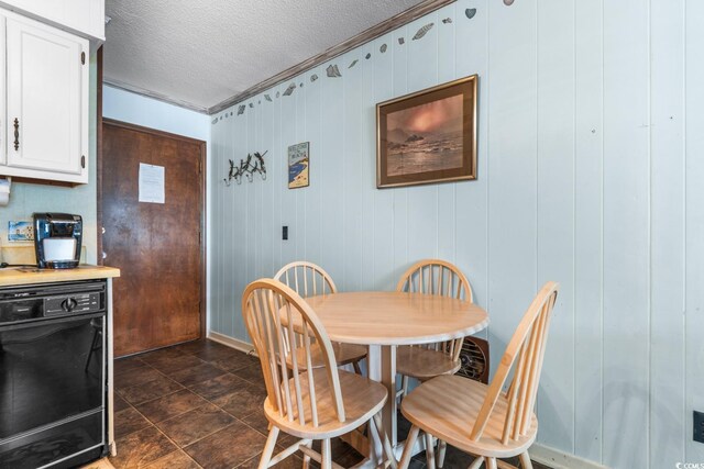 dining area with wood walls and a textured ceiling