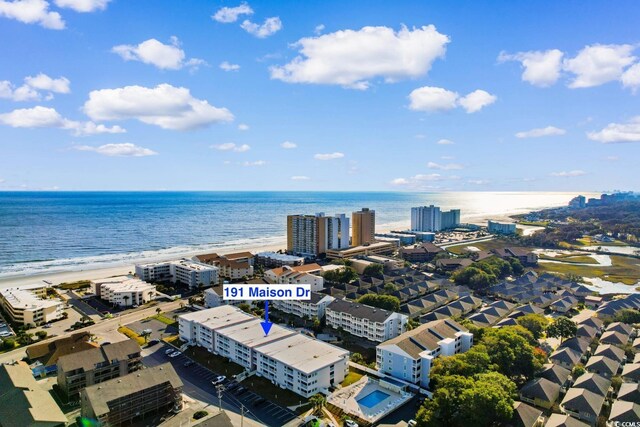 drone / aerial view featuring a beach view and a water view