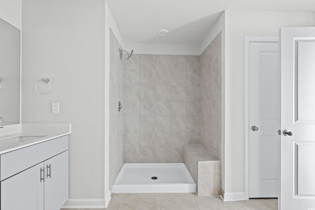 bathroom featuring vanity, tiled shower, and tile patterned flooring