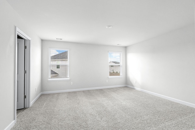 spare room featuring light colored carpet