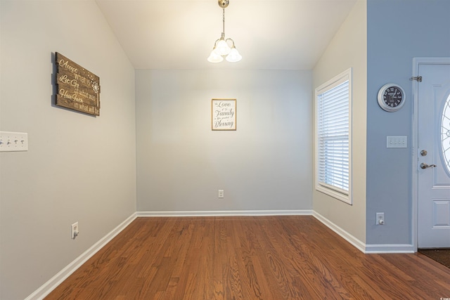 interior space featuring an inviting chandelier, baseboards, and wood finished floors