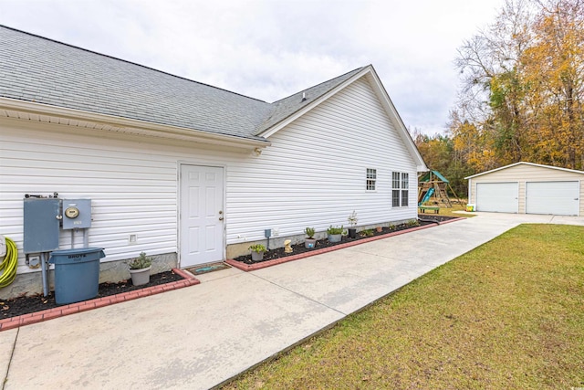 view of side of home with a playground, a garage, a shingled roof, an outdoor structure, and a yard