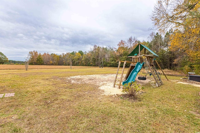 community jungle gym with a forest view, cooling unit, and a lawn