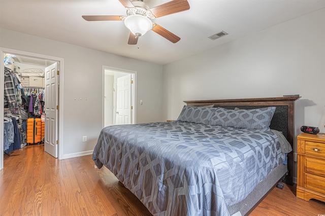 bedroom featuring visible vents, ceiling fan, wood finished floors, a spacious closet, and a closet