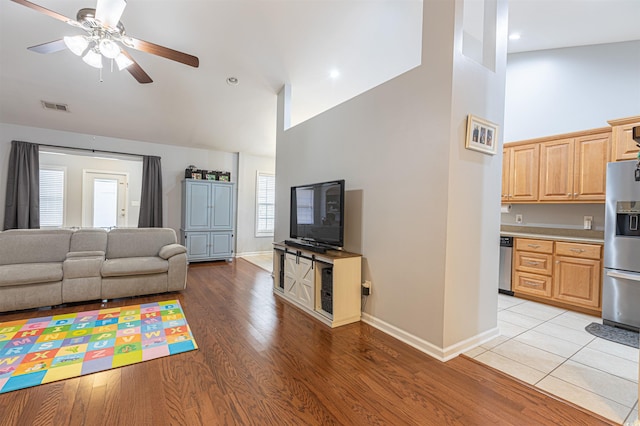 living room featuring light wood finished floors, visible vents, ceiling fan, high vaulted ceiling, and baseboards