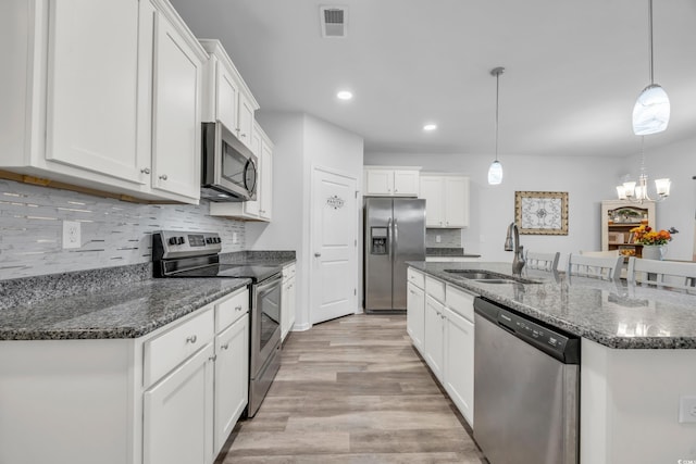 kitchen with pendant lighting, sink, white cabinetry, and stainless steel appliances