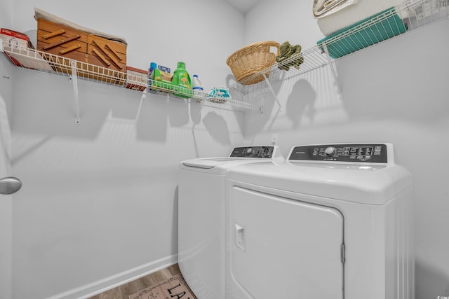 clothes washing area featuring washing machine and dryer and wood-type flooring