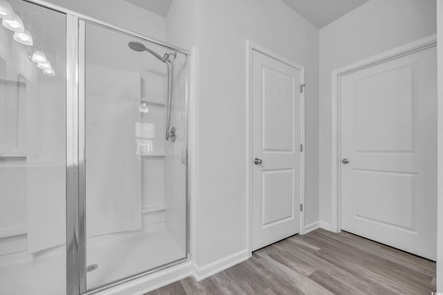 bathroom featuring hardwood / wood-style flooring and a shower with shower door