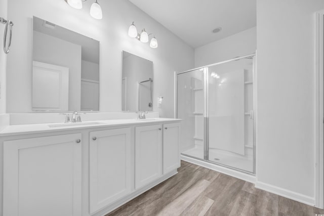 bathroom with walk in shower, vanity, and hardwood / wood-style flooring