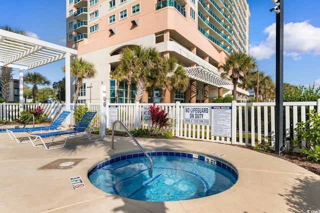 view of pool featuring a pergola and a hot tub