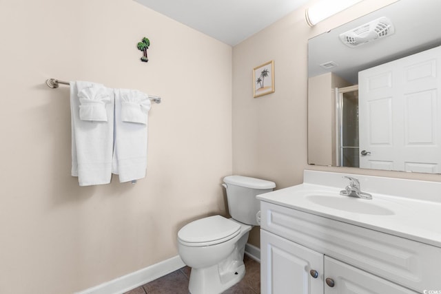 bathroom featuring tile patterned flooring, vanity, a shower with door, and toilet