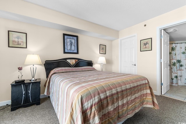 bedroom featuring connected bathroom, light colored carpet, and a textured ceiling