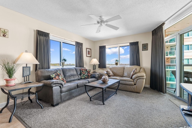 living room with ceiling fan, carpet, and a textured ceiling