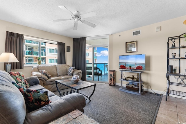 living room with light tile patterned floors, a textured ceiling, and ceiling fan