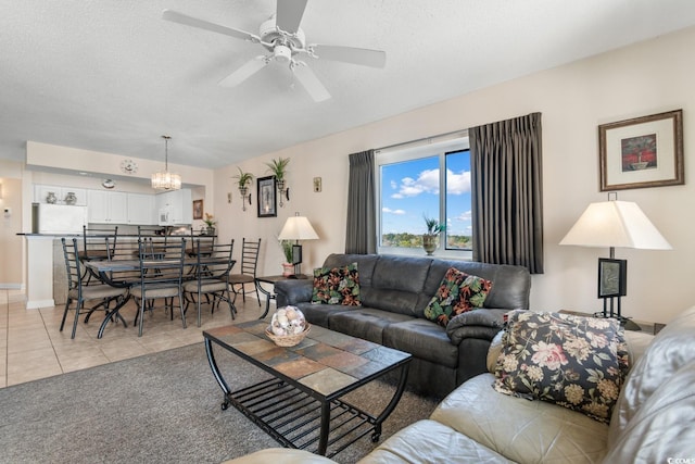 living room with ceiling fan, light tile patterned flooring, and a textured ceiling