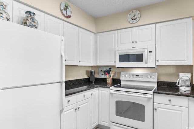 kitchen with white cabinets, white appliances, and dark stone countertops