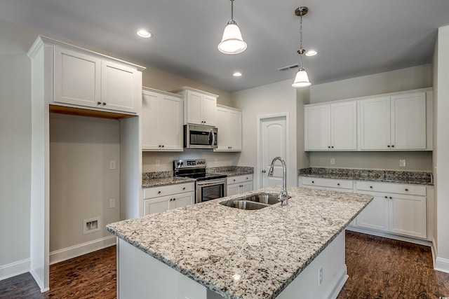 kitchen featuring hanging light fixtures, an island with sink, appliances with stainless steel finishes, and sink