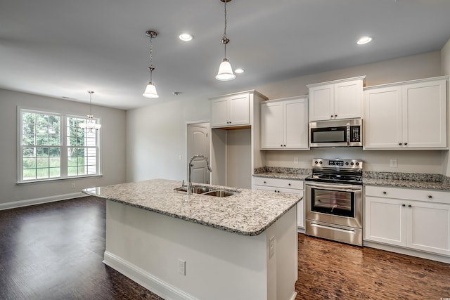 kitchen with an island with sink, stainless steel appliances, sink, and white cabinets