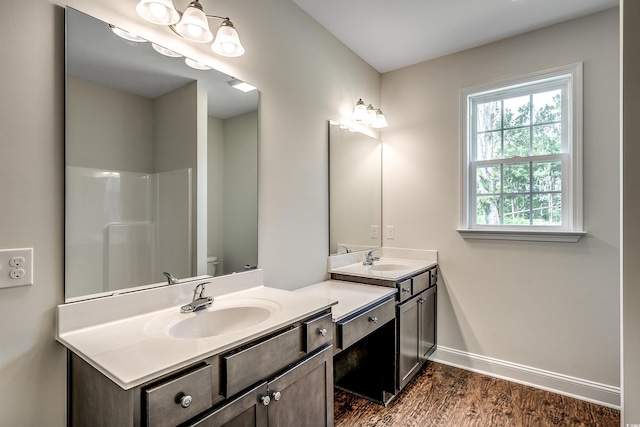 bathroom featuring vanity, hardwood / wood-style floors, a shower, and toilet