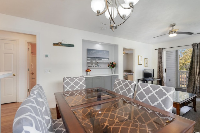 dining room featuring ceiling fan with notable chandelier and light wood-type flooring