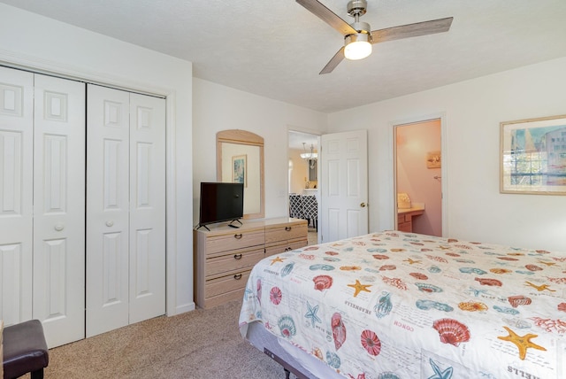 carpeted bedroom featuring ensuite bath, ceiling fan, a closet, and a textured ceiling