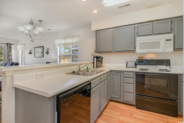 kitchen featuring kitchen peninsula, range with electric stovetop, a healthy amount of sunlight, and black dishwasher