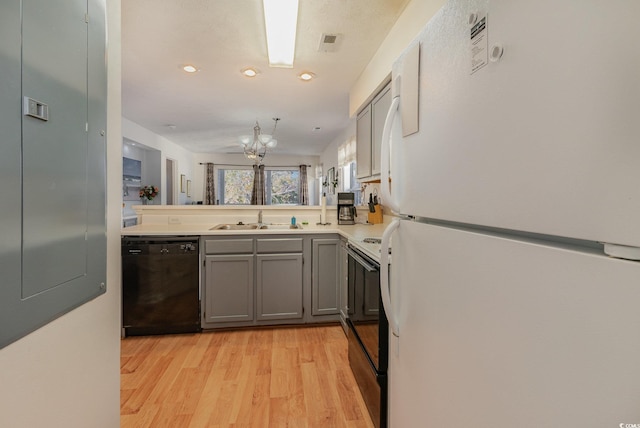 kitchen with gray cabinetry, sink, light hardwood / wood-style flooring, kitchen peninsula, and black appliances