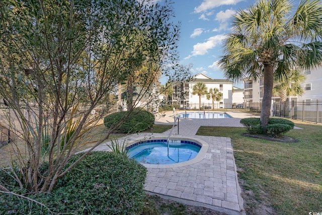 view of swimming pool with a lawn and a community hot tub