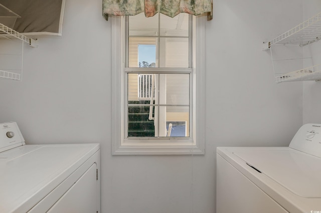 laundry room featuring washing machine and clothes dryer and a wealth of natural light