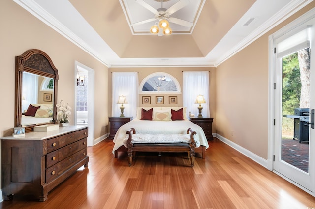 bedroom featuring access to outside, ceiling fan, ornamental molding, a tray ceiling, and light hardwood / wood-style floors