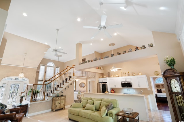 living room with light wood-type flooring and high vaulted ceiling