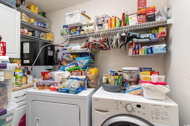 clothes washing area featuring separate washer and dryer and a textured ceiling