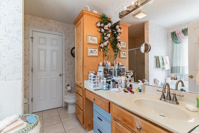 bathroom featuring vanity, a shower with door, tile patterned floors, toilet, and a textured ceiling