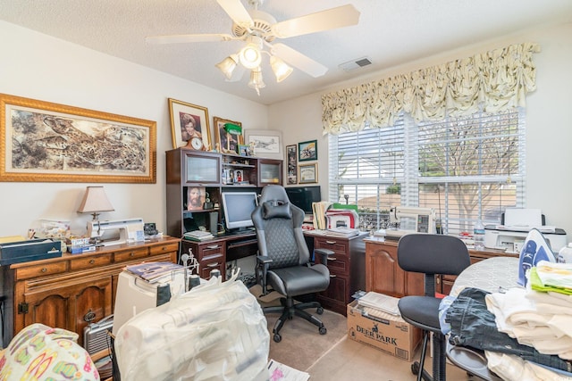 office space with ceiling fan, a textured ceiling, and light carpet