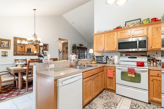 kitchen with kitchen peninsula, white appliances, sink, a notable chandelier, and hanging light fixtures