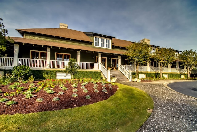 5801 Oyster Catcher Dr Unit 1022, North Myrtle Beach, SC 29582 - view of front facade featuring covered porch, stairs, and a chimney
