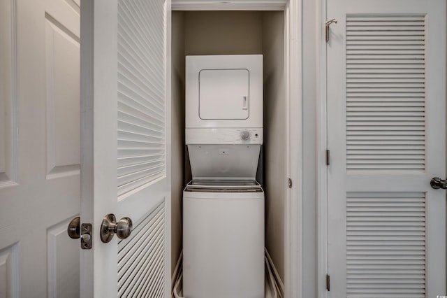 washroom with stacked washing maching and dryer