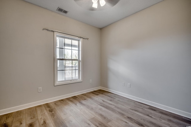 spare room with ceiling fan, light hardwood / wood-style floors, and a textured ceiling