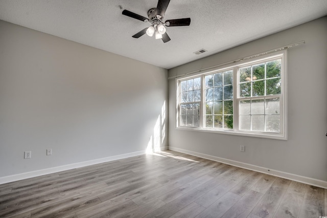 unfurnished room with ceiling fan, a textured ceiling, and light hardwood / wood-style flooring