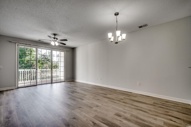 spare room featuring hardwood / wood-style floors, ceiling fan with notable chandelier, and a textured ceiling